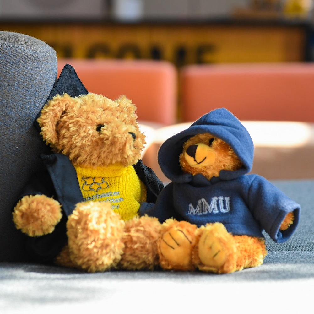 Two teddy bears wearing MMU branded clothing